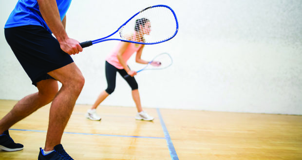 Two people playing tennis in a sports hall at Northumberland College