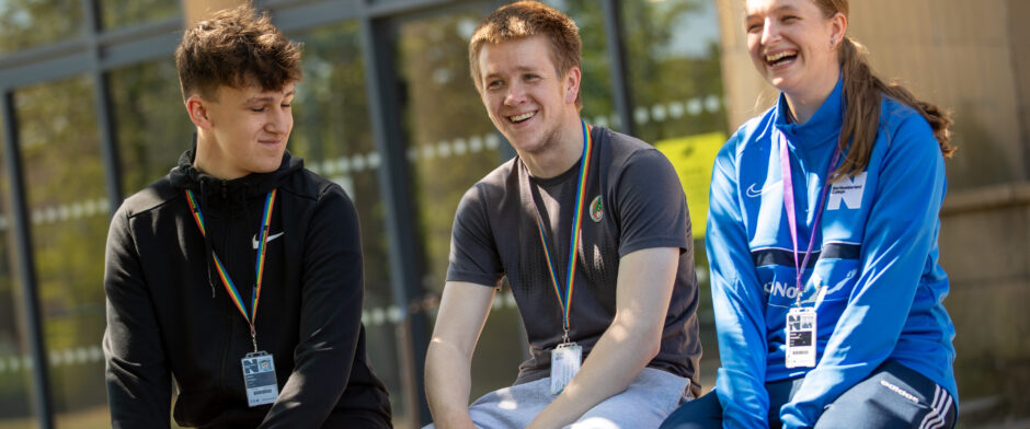 Three students smiling and laughing outside of Ashington Campus at Northumberland College