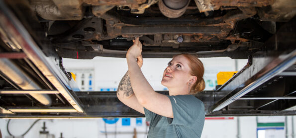 A Motor Vehicle student at Northumberland College Ashington Campus working on the underside of a car