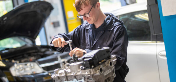 A Motor Vehicle student at Northumberland College Ashington Campus, working on the engine of a car